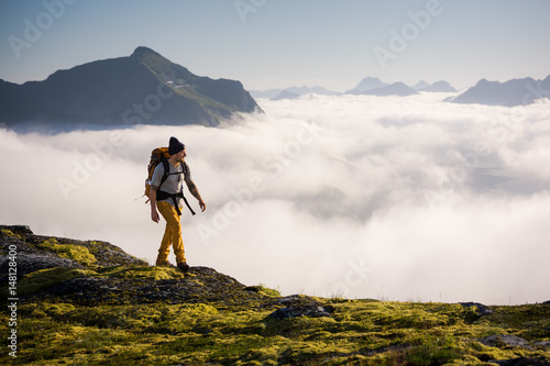 Man trekking high up in the mountains above the clouds  photo