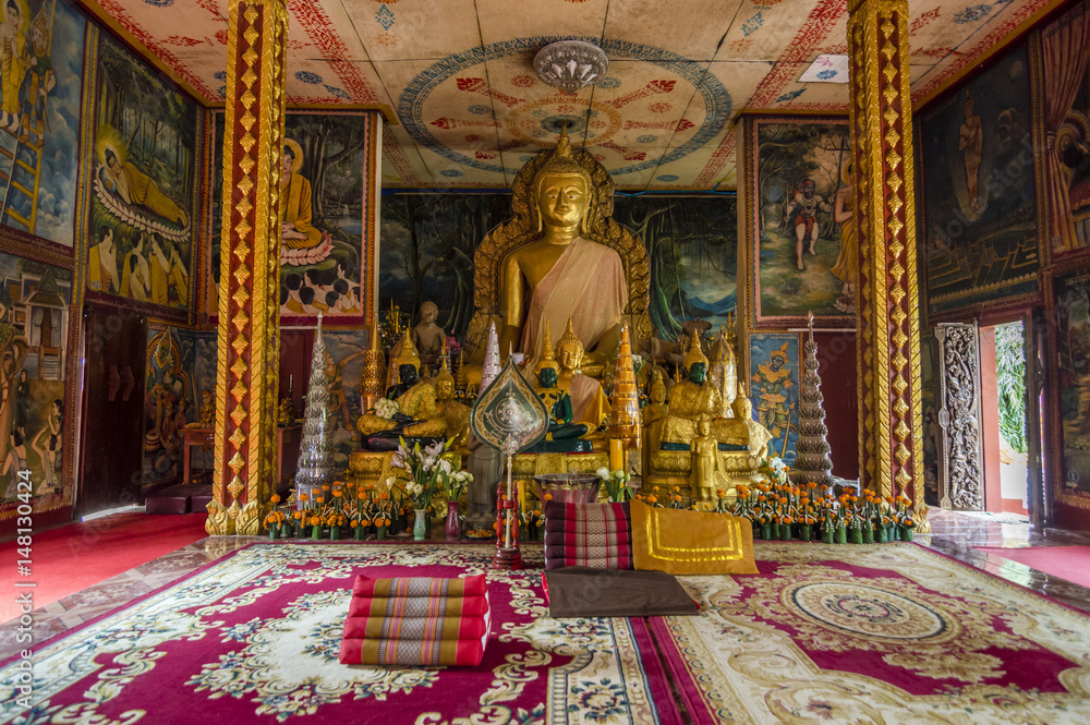 Fototapeta premium Gold Buddha statue inside the Wat Luang - buddhist temple in Pakse, Champasak province, Laos