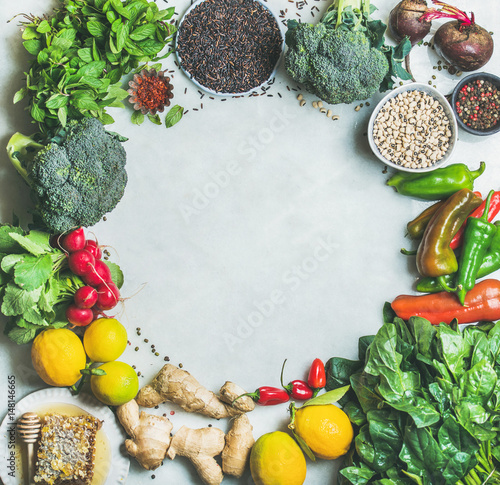 Clean eating healthy cooking ingredients. Vegetables, beans, grains, greens, fruit, spices over grey marble background, copy space, top view. Diet, vegetarian food concept Food frame