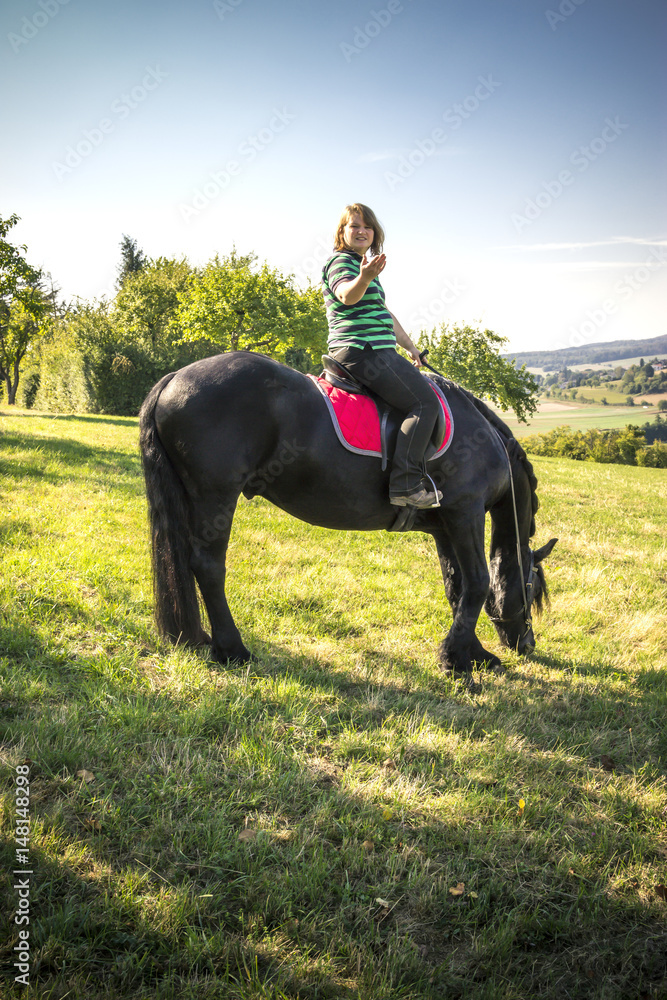 Junge Reiterin zeigt Landschaft