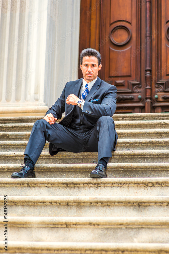 Middle Age American Businessman sitting on stairs outside vintage office in New York, taking work break, thinking