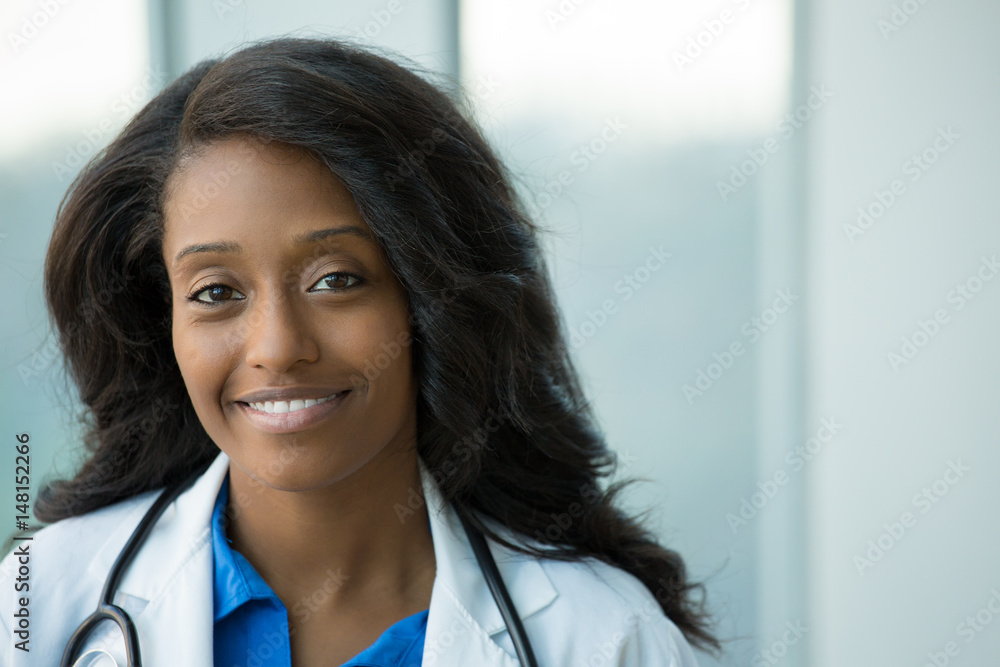 Closeup portrait of friendly, smiling confident female healthcare professional with lab coat, stethoscope, arms crossed. Isolated hospital clinic background. Time for an office visit Closeup portrait of friendly, smiling confident female healthcare professional with lab coat, stethoscope, arms crossed. Isolated hospital clinic background. Time for an office visit