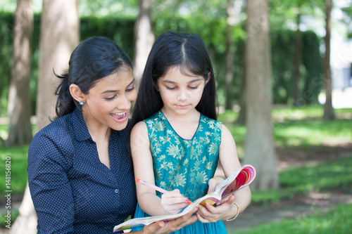 Quadro su tela Closeup portrait, young family enjoying coloring book, drawing, isolated outdoor