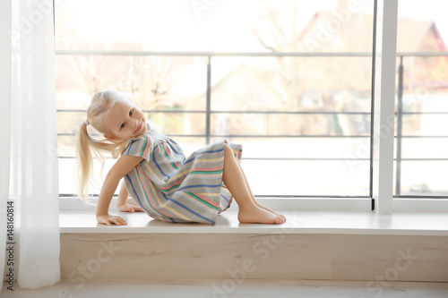 Cute little girl sitting on...