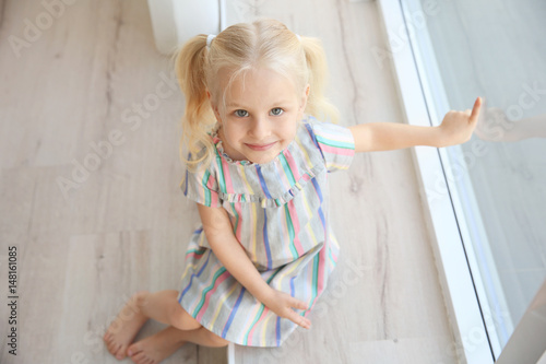 Cute little girl sitting on...