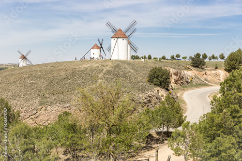 landscape with a road and white windmills in Mota del Cuervo, Province of Cuenca, Castilla La Mancha, Spain photo