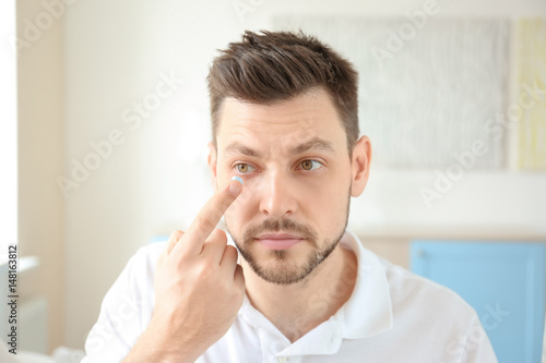 Young man putting contact l...