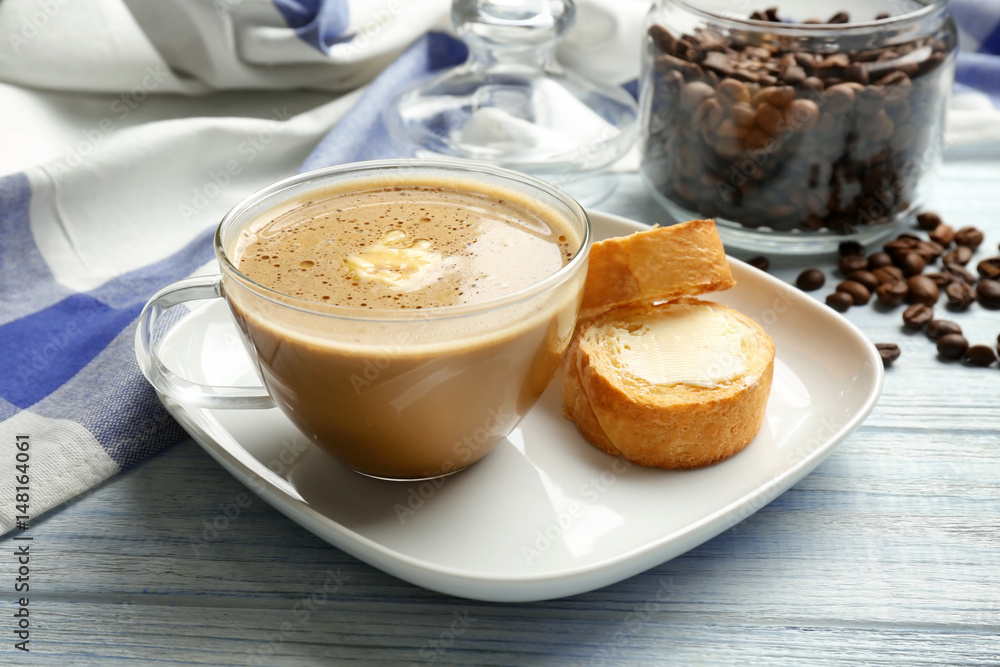 Composition with tasty butter coffee on wooden table