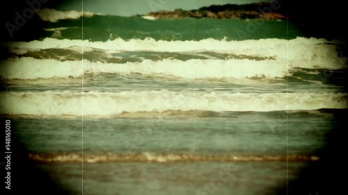 Retro style 1660s film of waves on a sandy beach photo