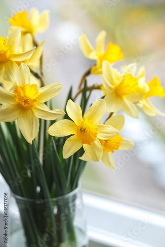 Fototapeta Naklejka Na Ścianę i Meble -  Spring easter background with daffodils in the bucket on the window .Yellow narcissus or daffodil flowers