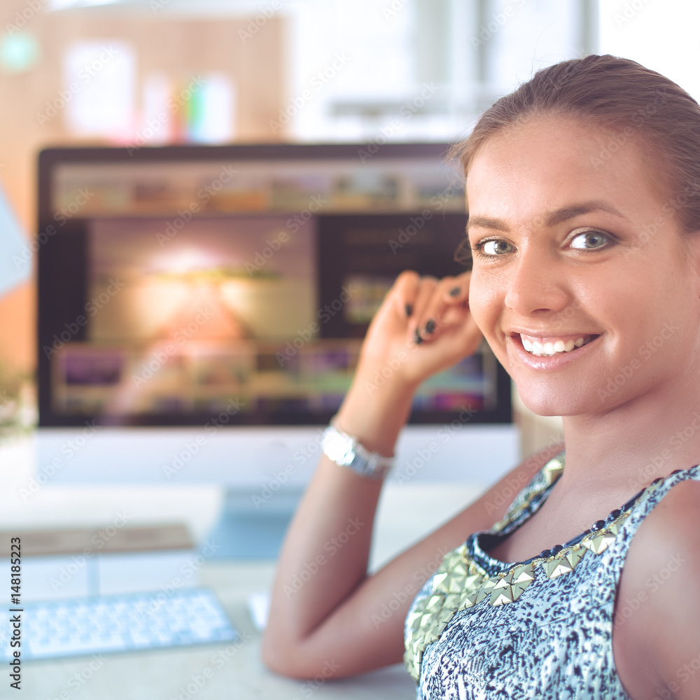 Young woman working in office, sitting at desk Young woman working in office, sitting at desk