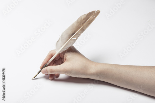 woman hand hold a fountain pen with ink on the white table.