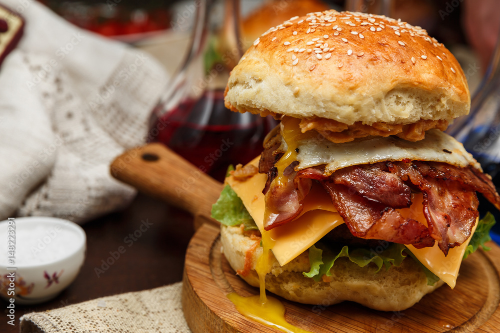 Bacon burger with beef patty and egg on wooden table