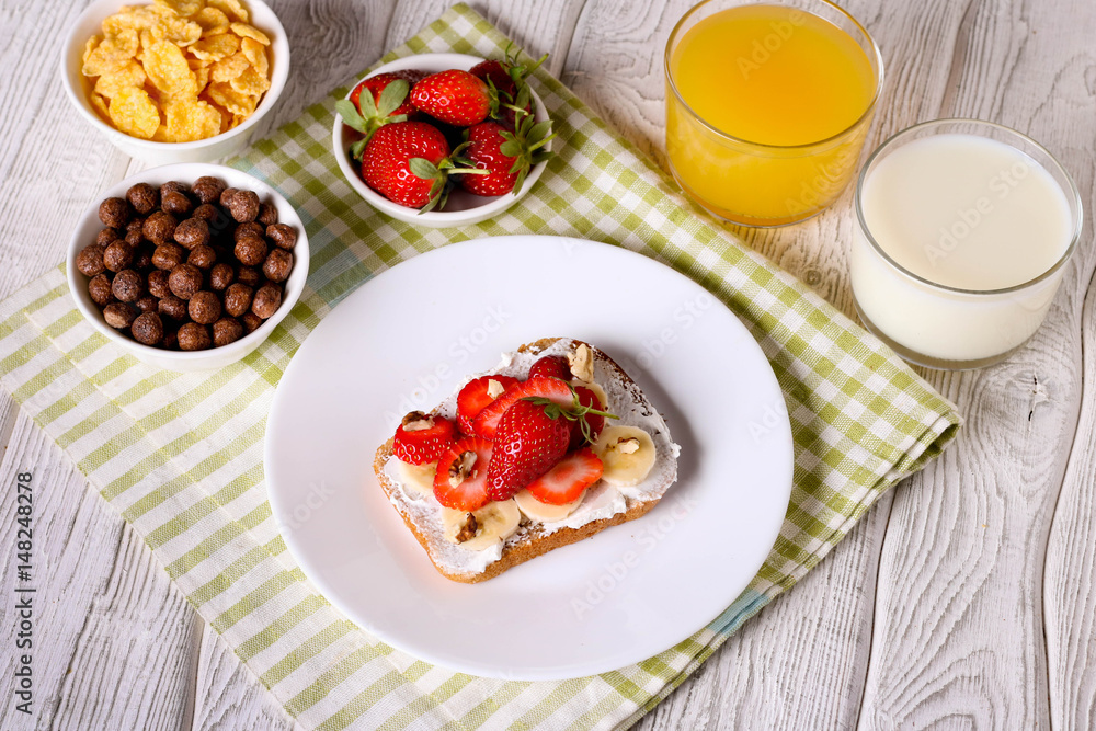 breakfast: Fresh toast with strawberry, banana and nuts, cornflakes, orange juice, milk breakfast: Fresh toast with strawberry, banana and nuts, cornflakes, orange juice, milk