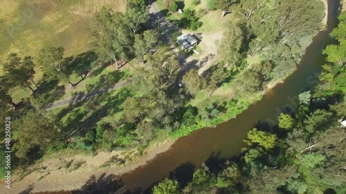 Forward flight over small river looking straight down at treetops photo