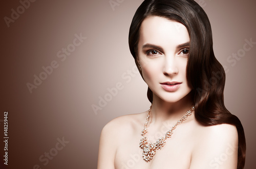 Beautiful model girl with long wavy and shiny hair . Woman with curly hairstyle. Face with clean fresh skin close up.