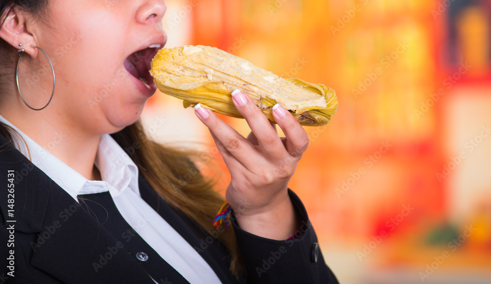 Gorgeous woman eating a delicious humita, traditional andean food concept Gorgeous woman eating a delicious humita, traditional andean food concept