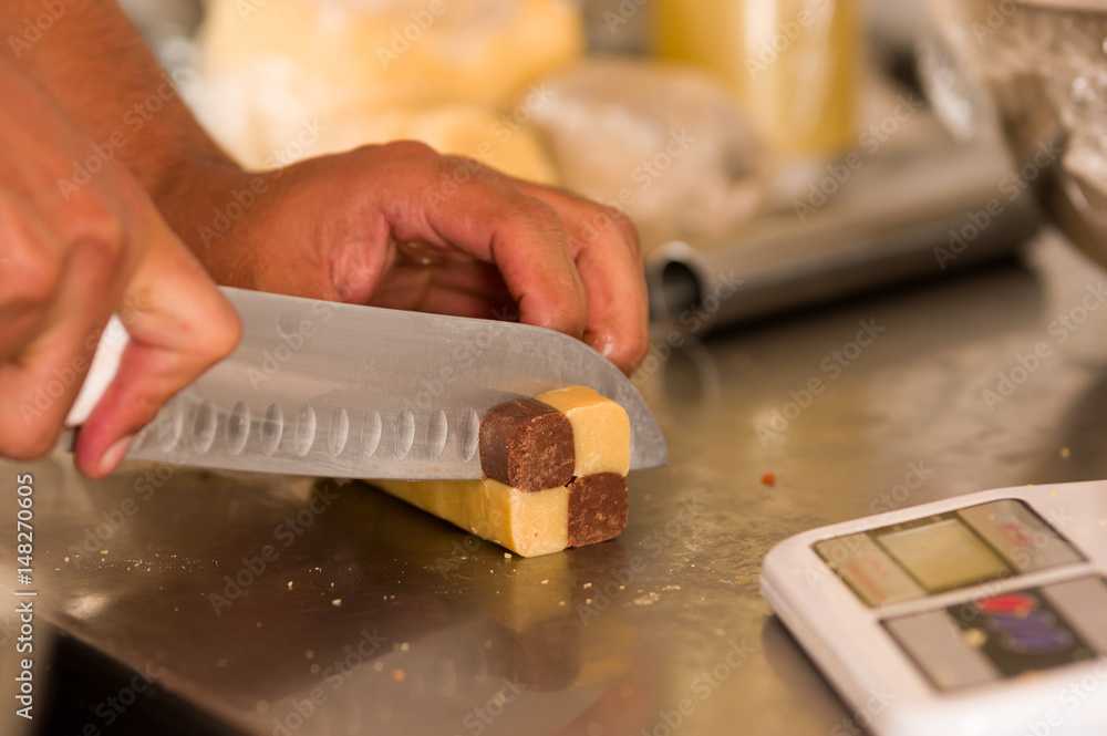 Bakery man cutting a delicious christmas fudge in a bakery store Bakery man cutting a delicious christmas fudge in a bakery store