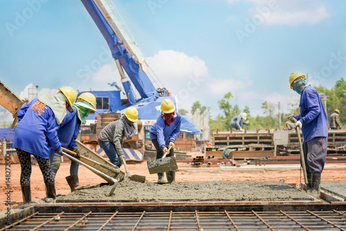 Construction worker Concrete pouring during commercial concreting floors of building in construction site and Civil Engineer or Construction engineer inspec work
