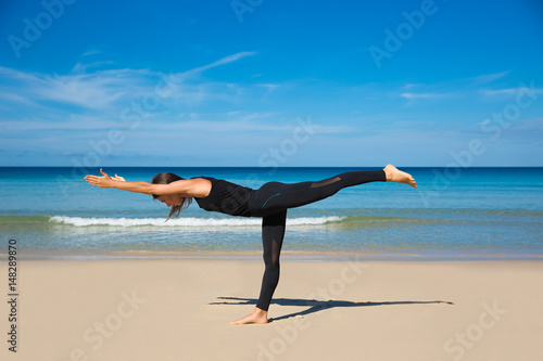 Healthy yoga exercise on the beach, slim sporty body training, leisure and meditation, vacation, sport, health care concept, over natural background blue sky and sea. Ashtanga vinyasa