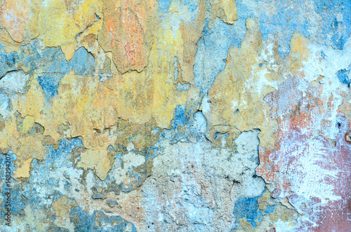 Shabby grunge texture of a stucco coated plaster wall with many layers of paint