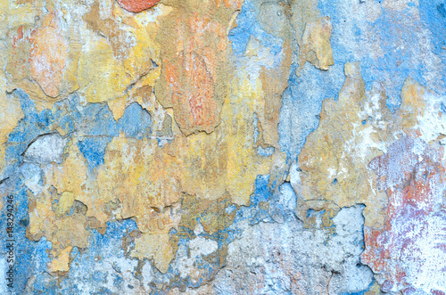 Shabby grunge texture of a stucco coated plaster wall with many layers of paint