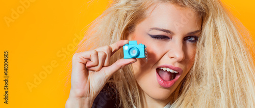 Foto Beautiful girl portrait holding mini toy camera and winking, letterbox