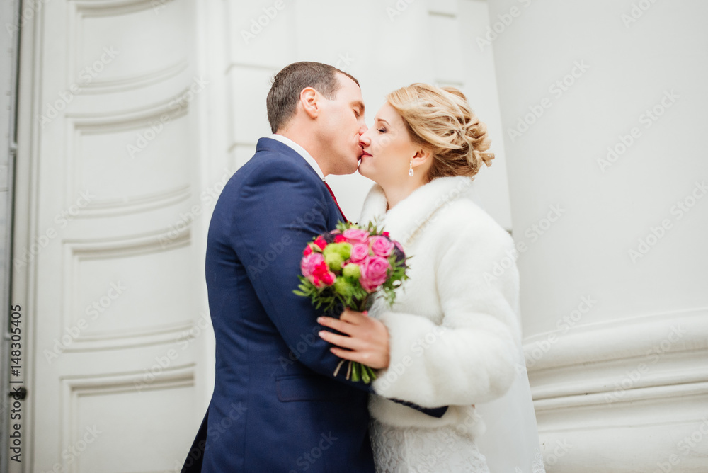 Bride and groom at wedding Day walking Outdoors near architecture. Bridal couple, Newlywed woman and man embracing with love. Happy bride and elegant groom kissing. Bride and groom at wedding Day walking Outdoors near architecture. Bridal couple, Newlywed woman and man embracing with love. Happy bride and elegant groom kissing.