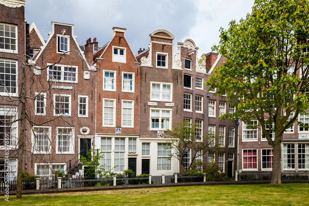 Begijnhof houses and garden in Amsterdam, Netherlands. The Begijnhof is one of the oldest inner courts in the city of Amsterdam