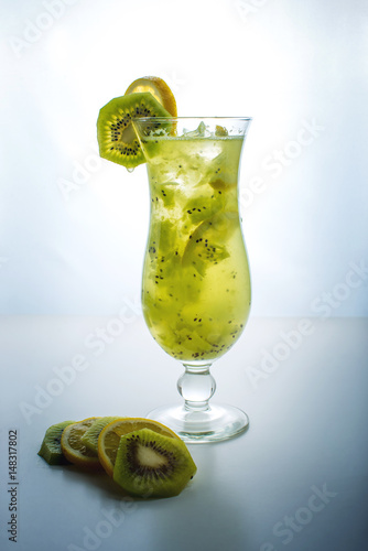 Fruit lemonade in hurricane glass with kiwi and lemon