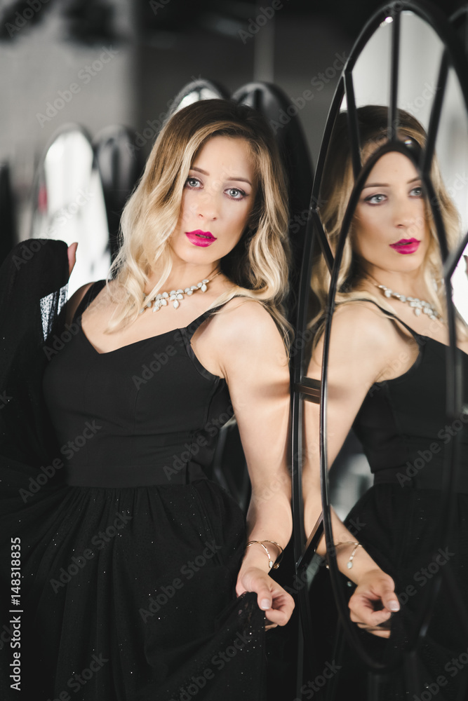 The beautiful lady stands near mirror The beautiful lady stands near mirror