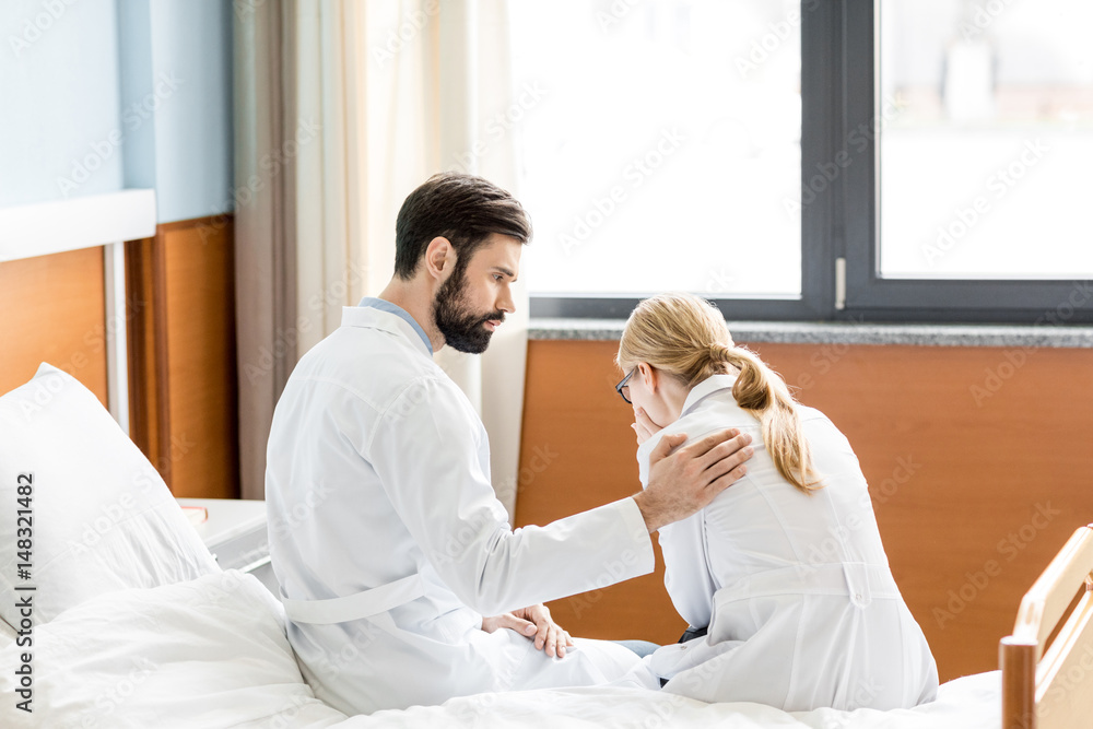 doctor soothing upset colleague doctor soothing upset colleague