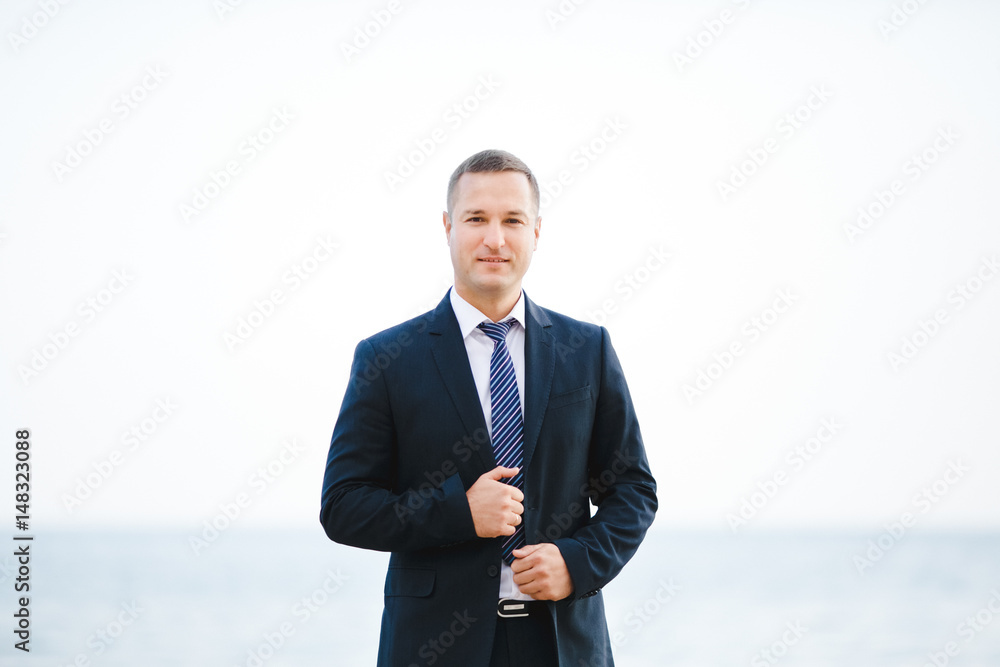 The handsome groom stands near sea The handsome groom stands near sea
