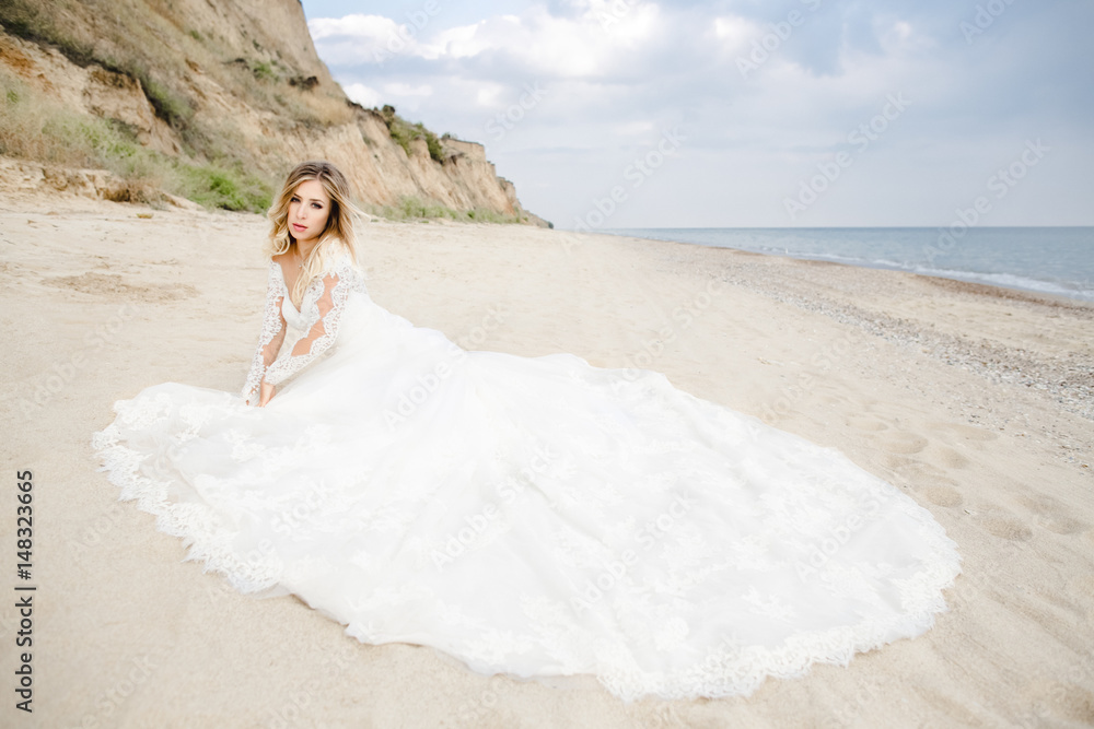 The beautiful bride sitting on the sand