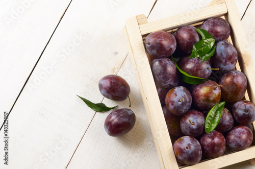 Wooden crate with plums