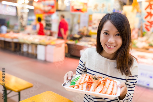 Woman holding tray of crab