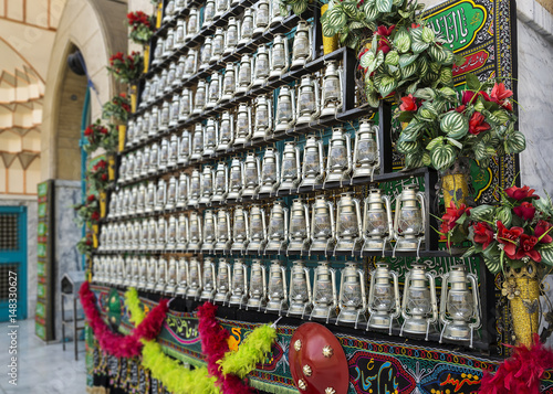 Принти на полотні TEHRAN, IRAN - October 12, 2016: lanterns and Shiite saints' names embroidered and printed on fabrics in front of a mosque, as a symbol of mourning of Imam Husayn martyrdom in the Battle of Karbala