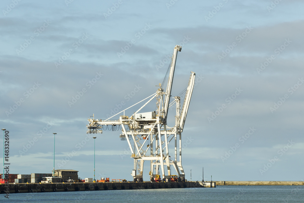 Fototapeta premium Large cranes on the wharf of a harbor