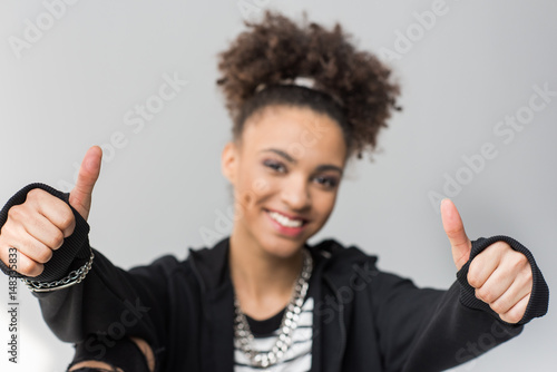 portrait of african american girl showing thumbs up isolated on grey
