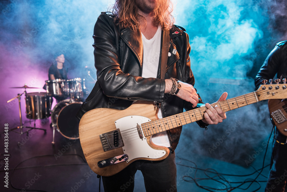 Obraz premium Przycięte strzał gitarzysta elektryczny grający muzykę rockową na scenie