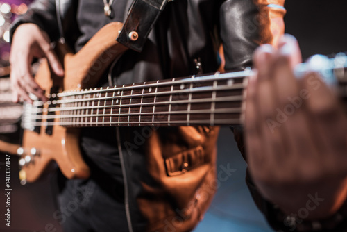 Close-up partial view of rock star playing hard rock music on stage