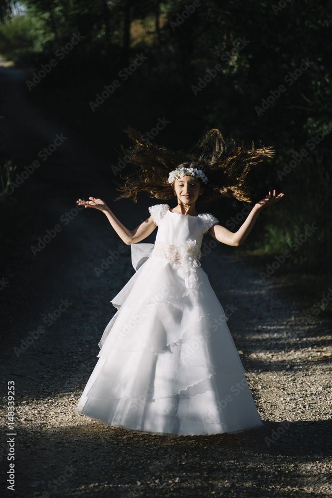 Fototapeta premium Attractive blond girl in forest dressed in communion