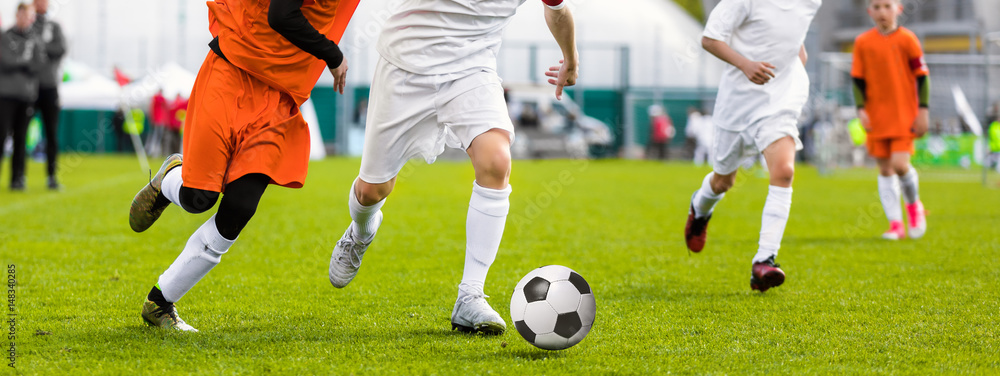 Running Young Soccer Football Players. Footballers Kicking Football Match Game. Youth Soccer Players Running After the Ball. Coach and Soccer Stadium in the Background Running Young Soccer Football Players. Footballers Kicking Football Match Game. Youth Soccer Players Running After the Ball. Coach and Soccer Stadium in the Background