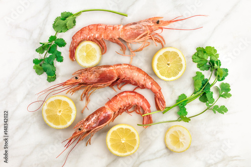 Raw shrimps with slices of lemon, cilantro, and copyspace