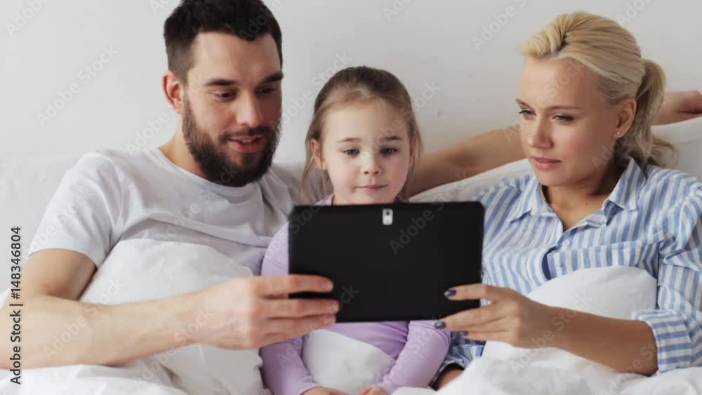 happy family with tablet pc in bed at home happy family with tablet pc in bed at home