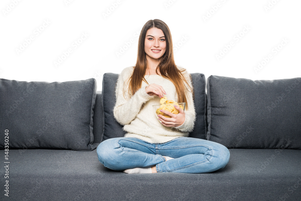 Young woman watching TV and eating chips on sofa Young woman watching TV and eating chips on sofa