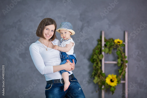 A happy mother and her young daughter are having fun. They are both laughing. They are having casual clothes and floral wreathes on. The atmosphere of happiness is all around them. photo