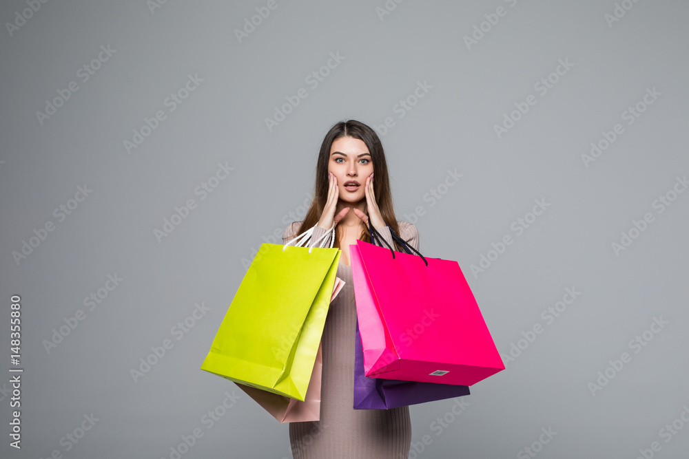 Young happy woman shopping bags over grey background