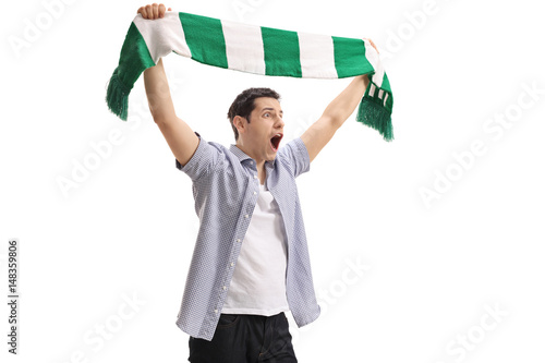 Ecstatic football fan holding a scarf and cheering photo