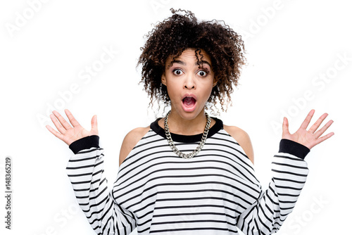 young shocked african american woman looking at camera isolated on white